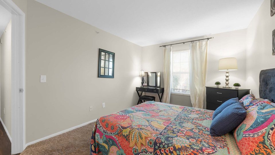 a bedroom with a colorful bed and a large mirror at The Sawmill Park
