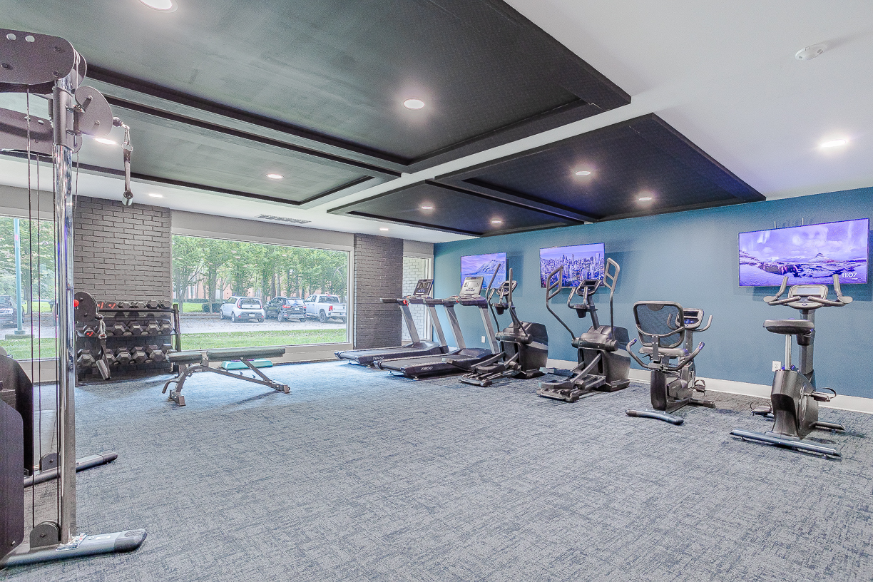 a gym room with exercise equipment and television at The Edgewater