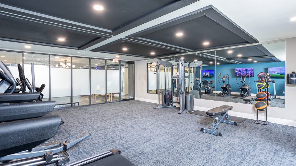 a gym room with exercise equipment and mirrors at The Edgewater