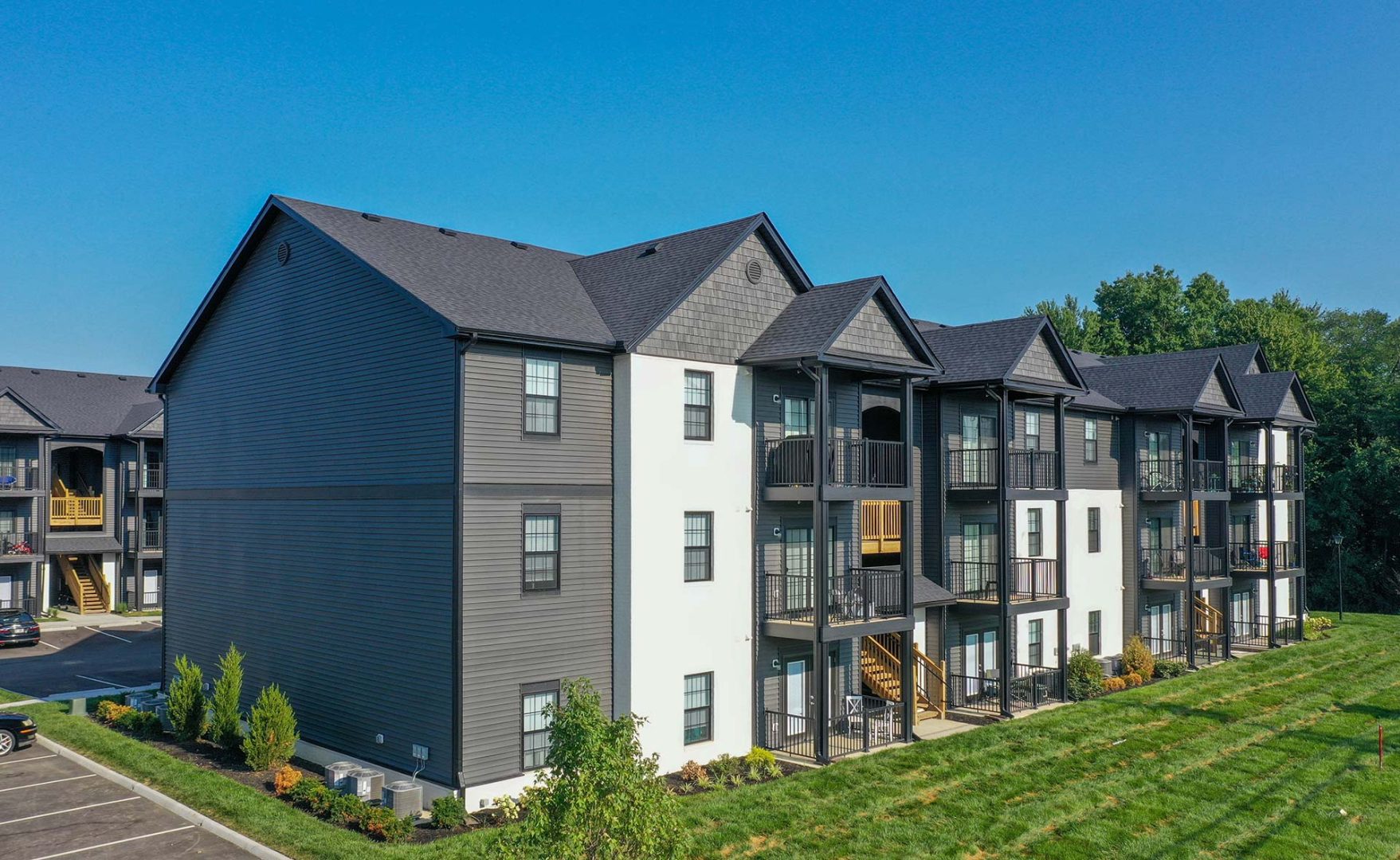 the exterior of an apartment complex with a green lawn at The Adams Pointe