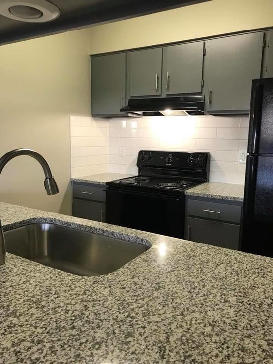 a kitchen with black appliances and granite counter tops at The Lakeside Village