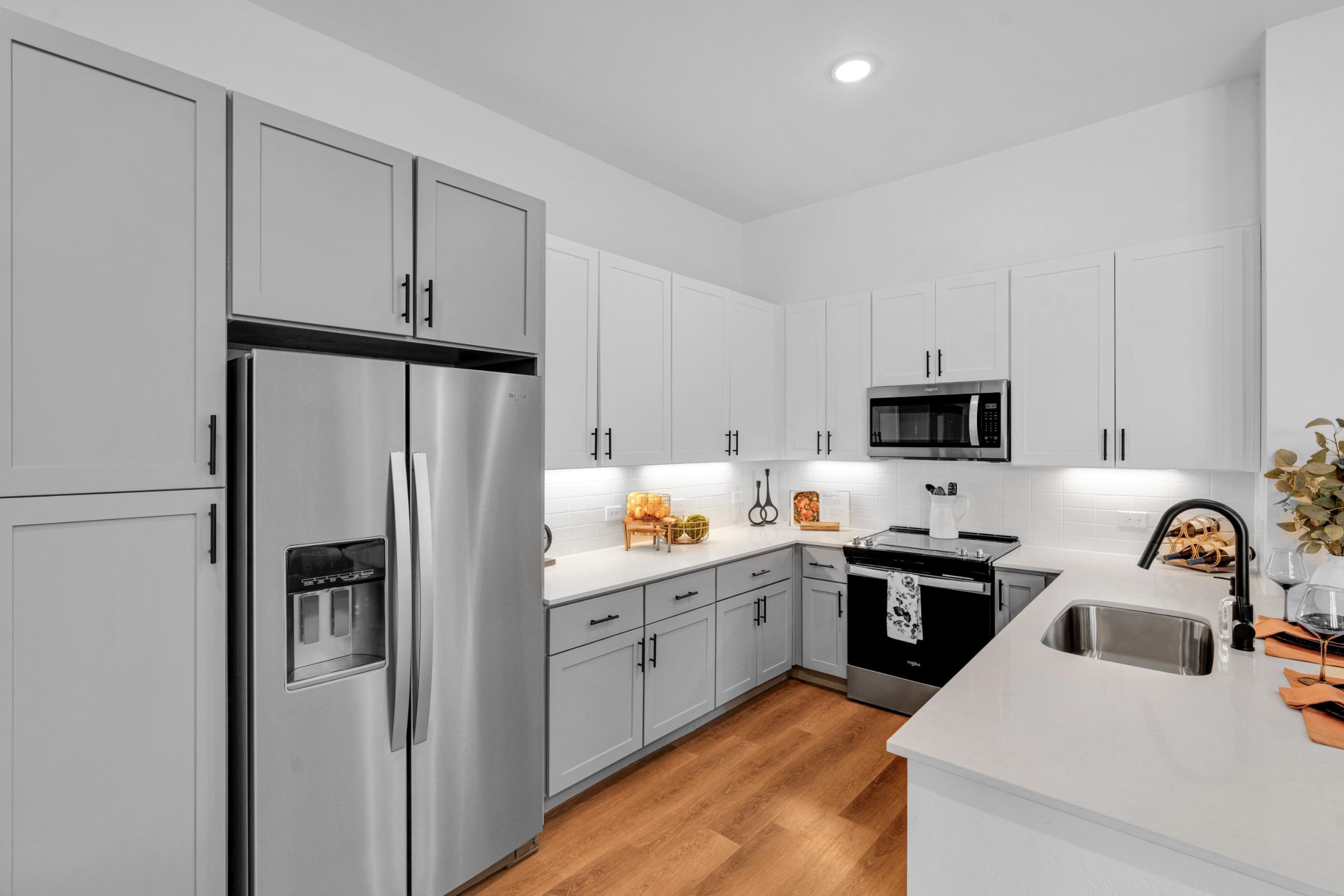 a clean kitchen with stainless steel appliances and white cabinets at The parcHAUS at Firewheel Parkway