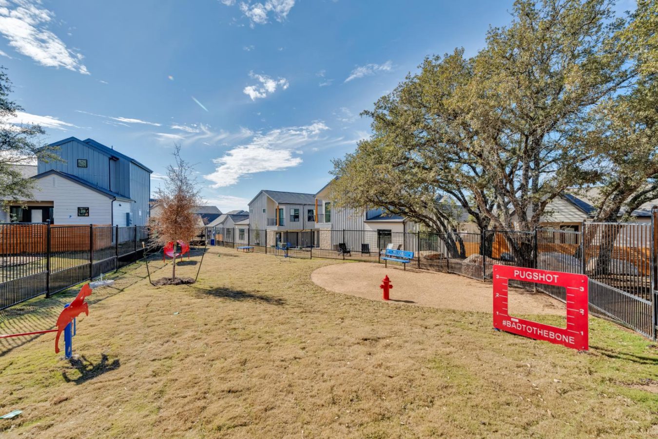 a playground area with a swing set and a tree at The parcHAUS at Mustang Drive