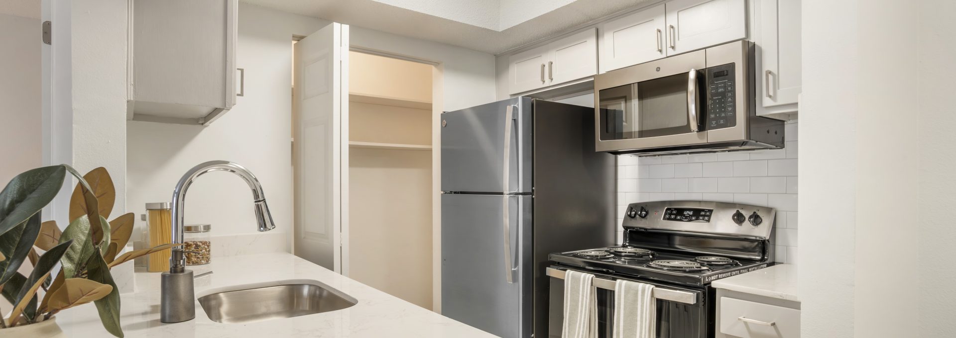a kitchen with stainless steel appliances and white cabinets at The  Marley
