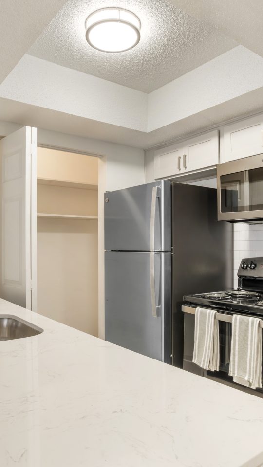 a kitchen with stainless steel appliances and white cabinets at The  Marley