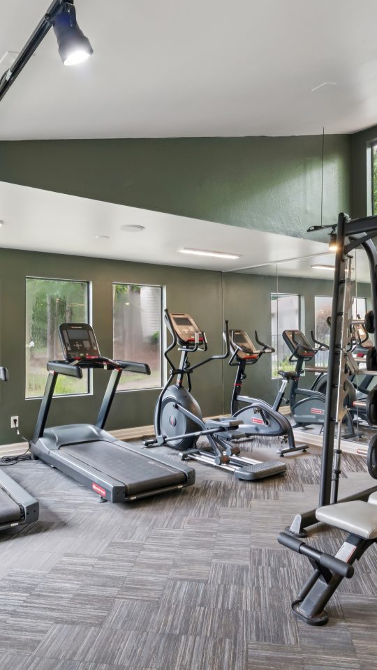 a gym room with tread machines and exercise equipment at The  Marley