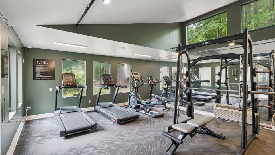 a gym room with tread machines and exercise equipment at The  Marley