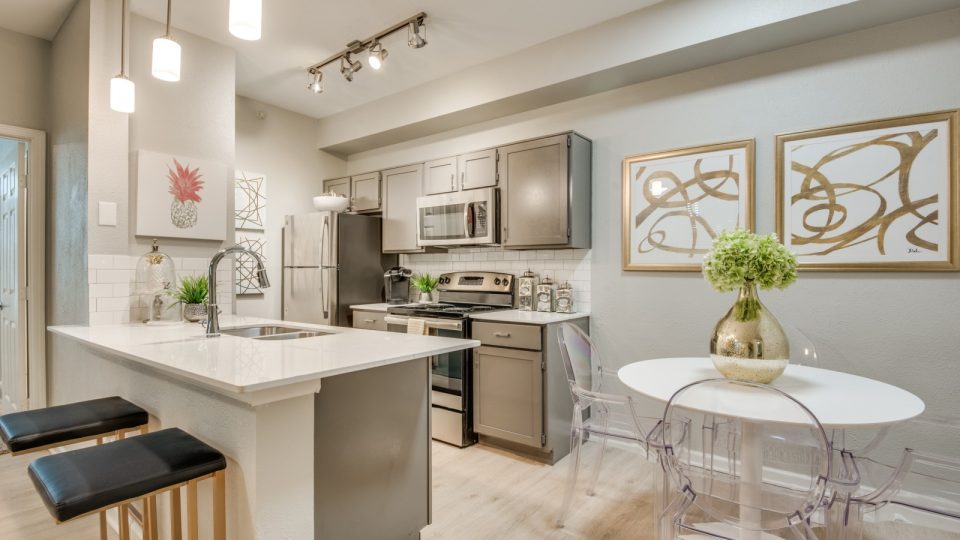 a kitchen with white cabinets and stainless steel appliances at The  Sophia