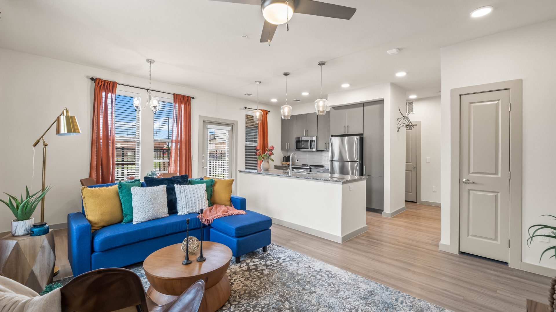 a living room with blue couches and a ceiling fan at The La Ventana