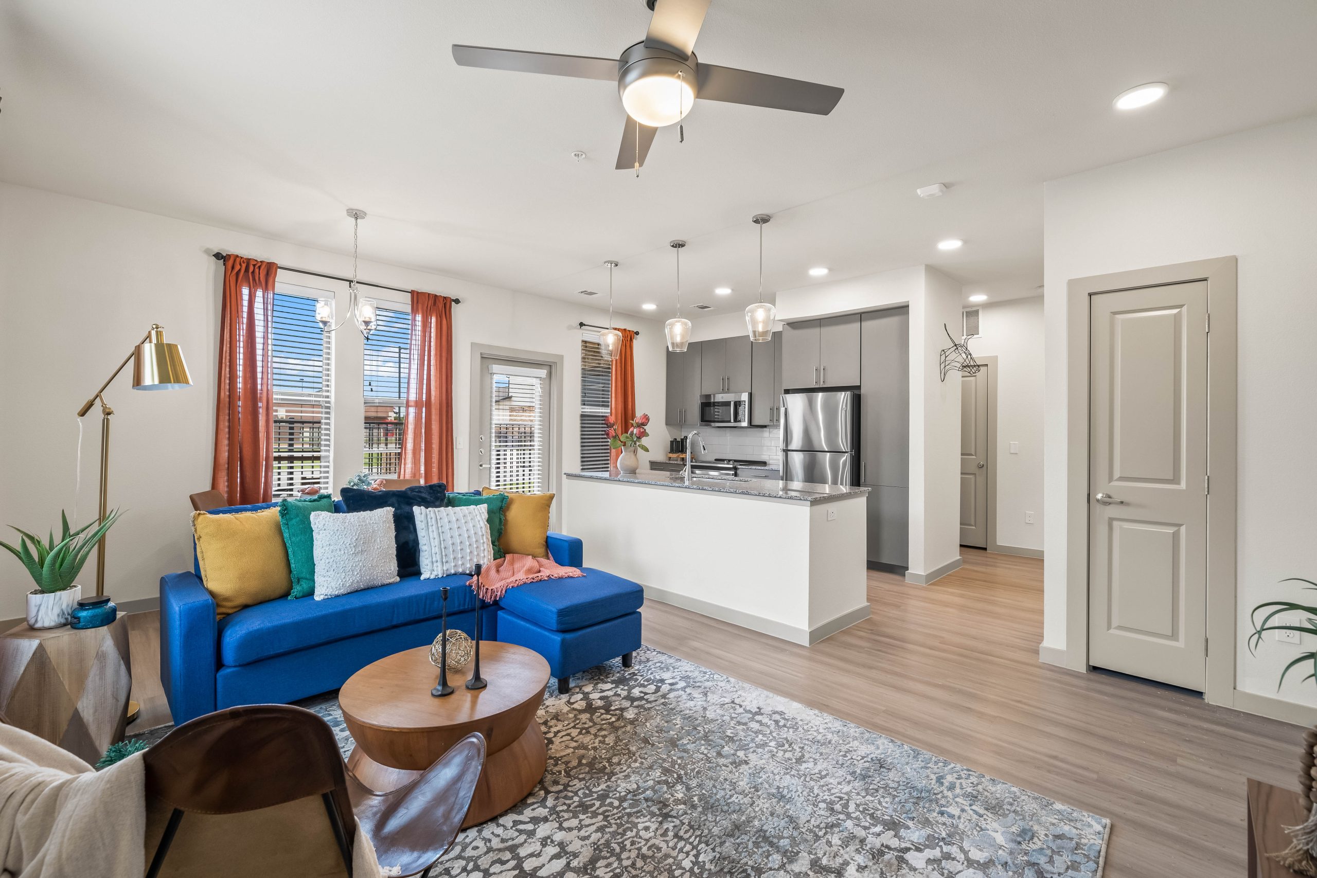 a living room with blue couches and a ceiling fan at The La Ventana