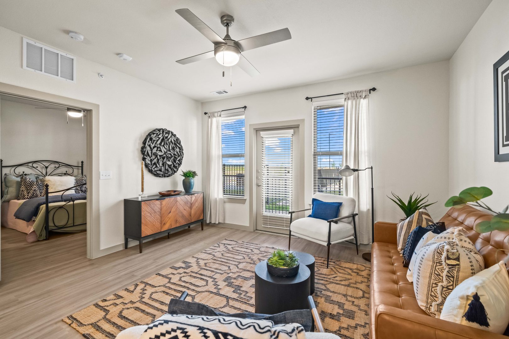 the living room has a ceiling fan and a large window at The La Ventana