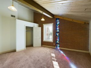 a room with a stained glass window and a carpet at The Beacon Hill Apartments