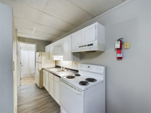 a kitchen with white appliances and a stove at The Beacon Hill Apartments