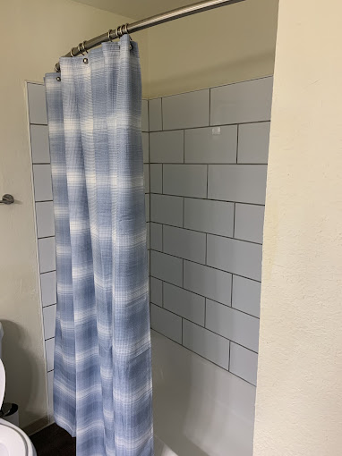 a bathroom with a blue and white shower curtain at The Kings Lofts