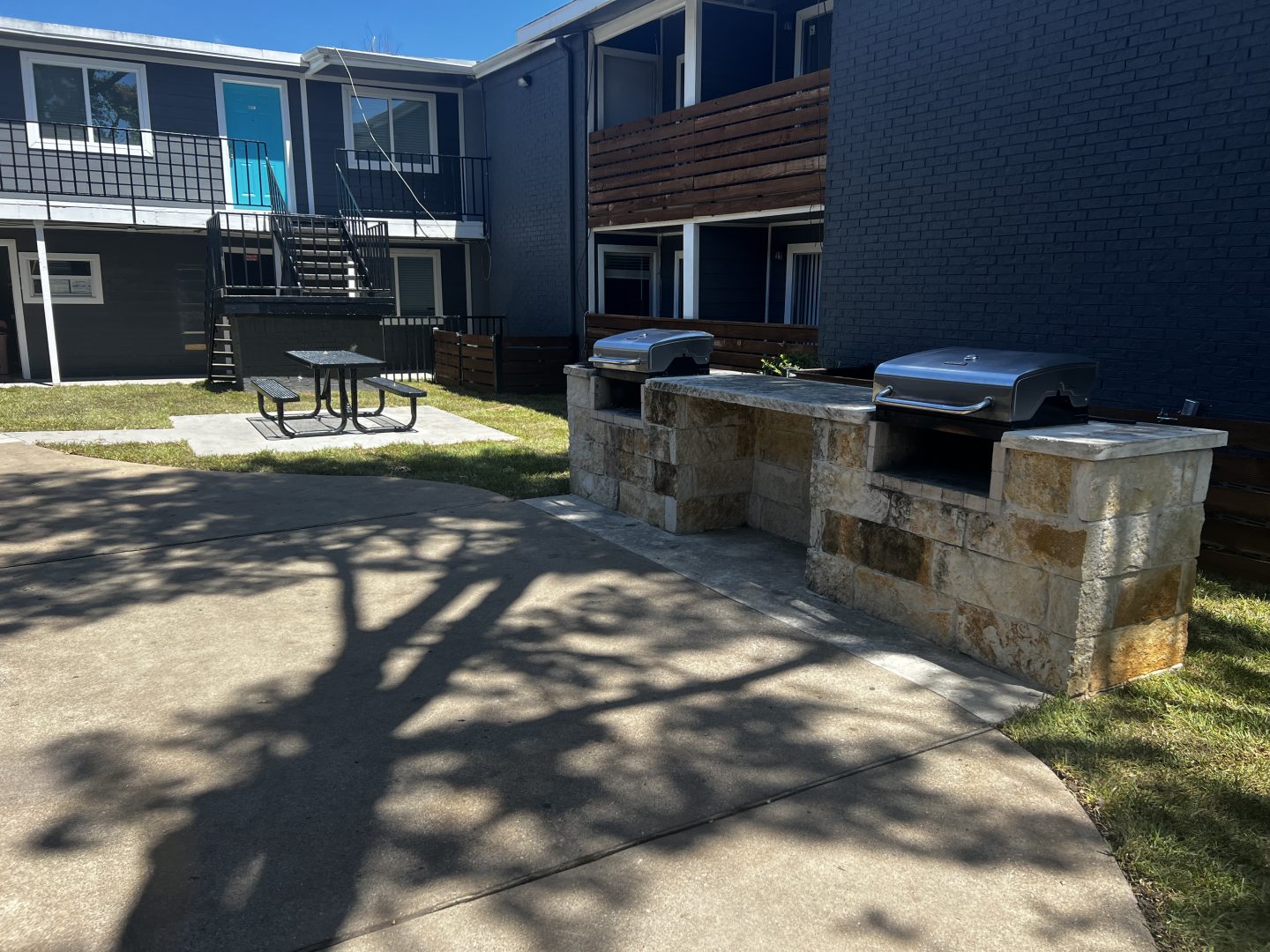 a patio with a grill and a barbecue at The Calypso Court Apartments