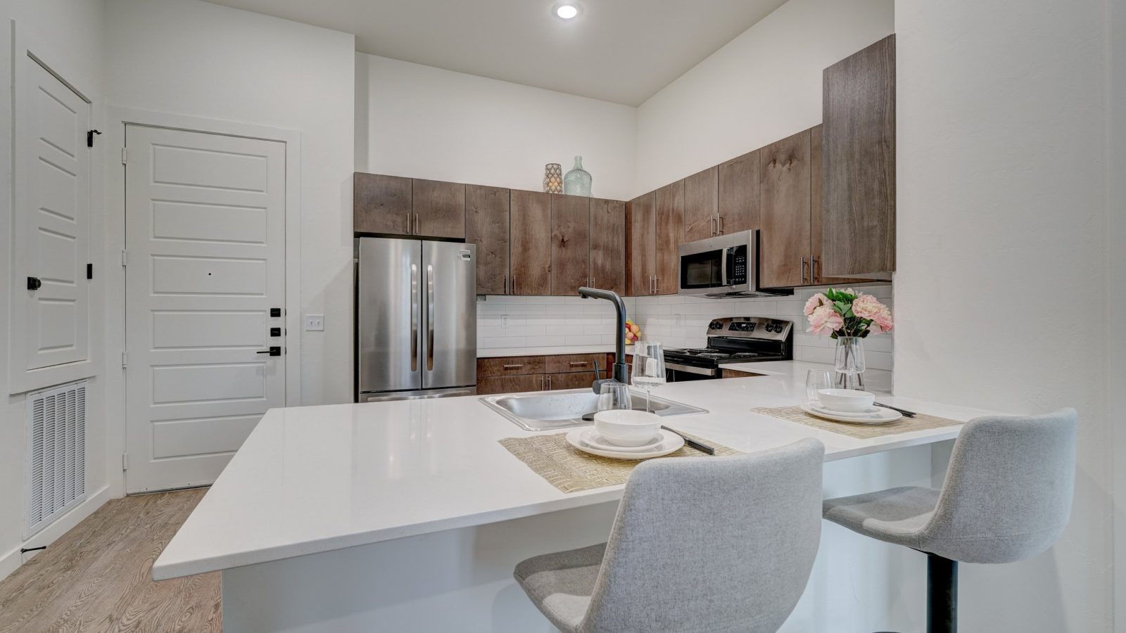 a kitchen with white cabinets and stainless steel appliances at The Campbell