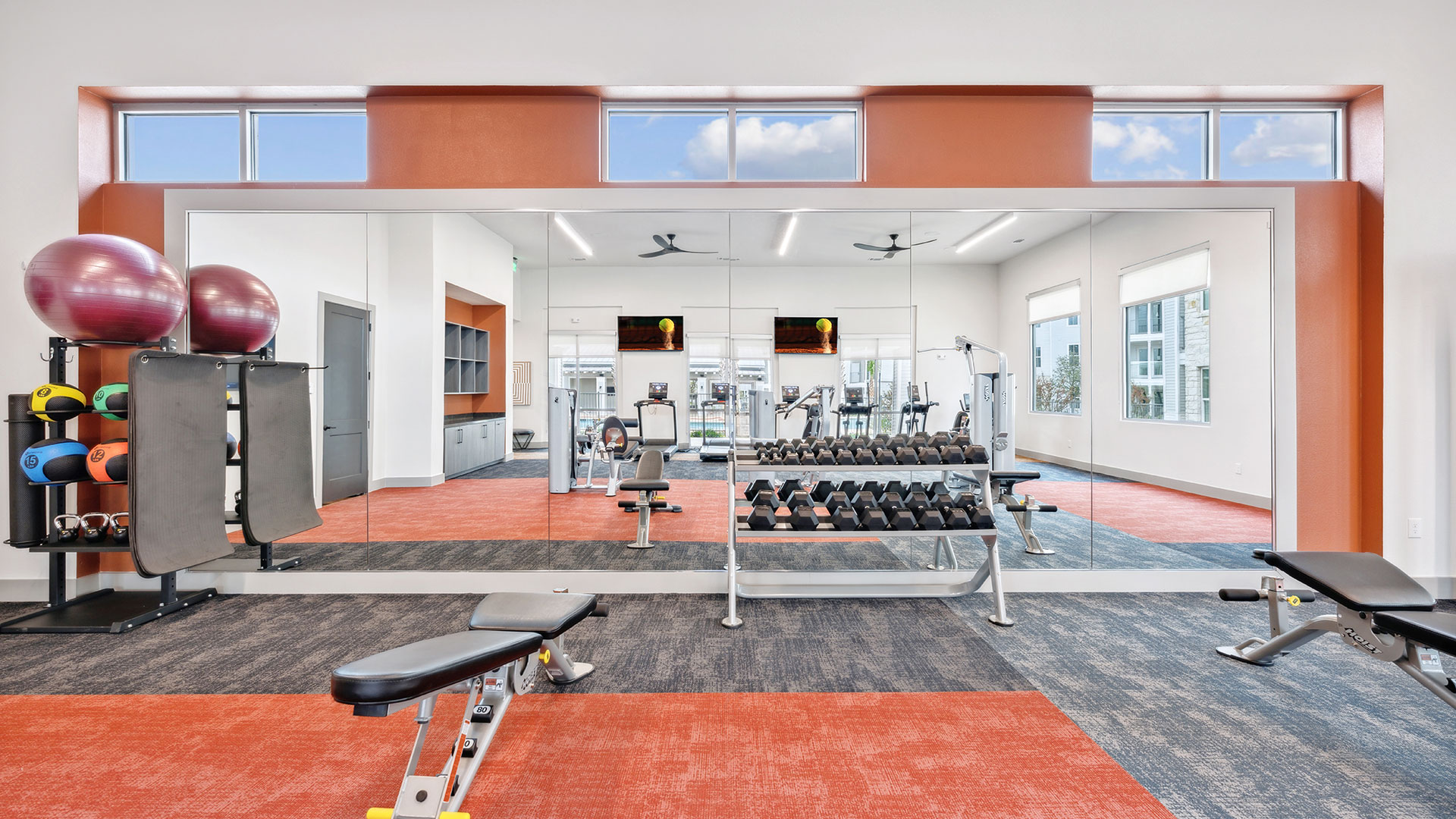 a gym room with a large exercise equipment and mirrors at The Legacy at Veramendi