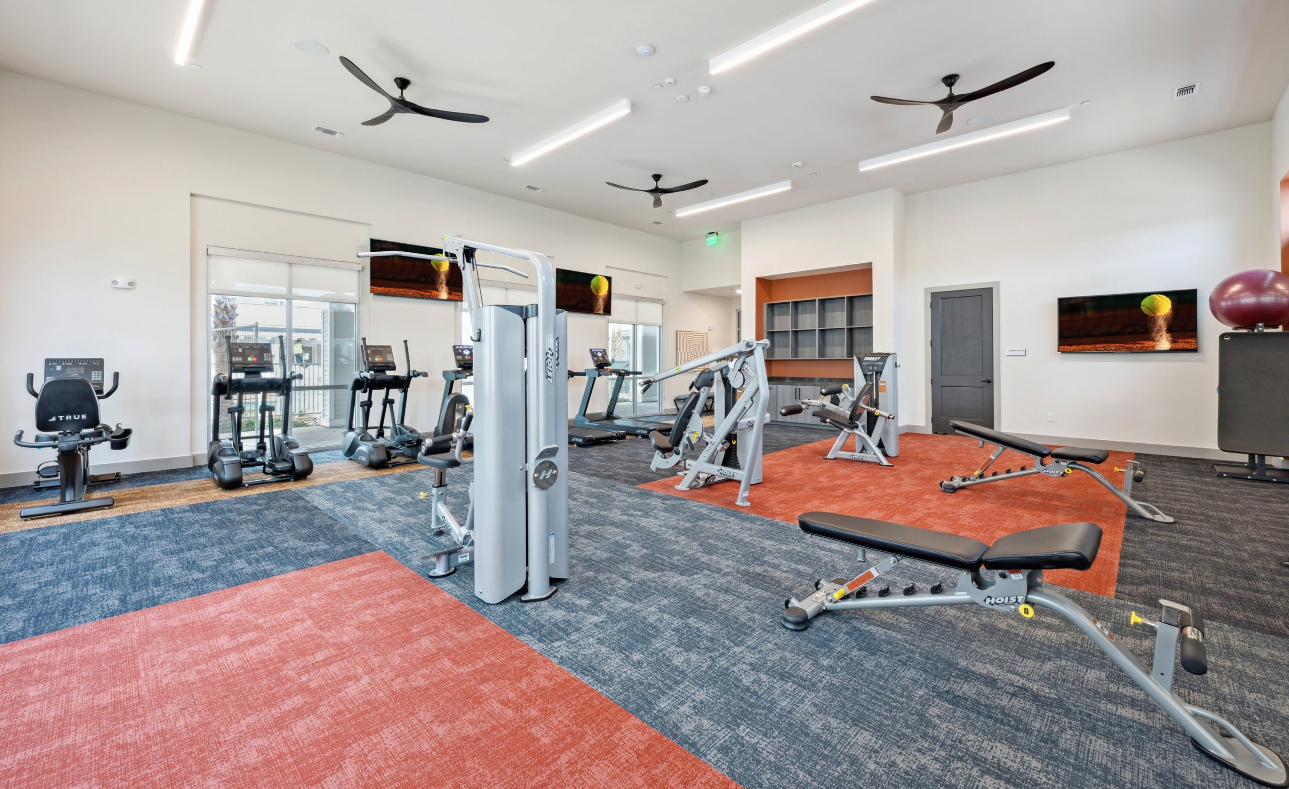 a gym room with exercise equipment and a television at The Legacy at Veramendi