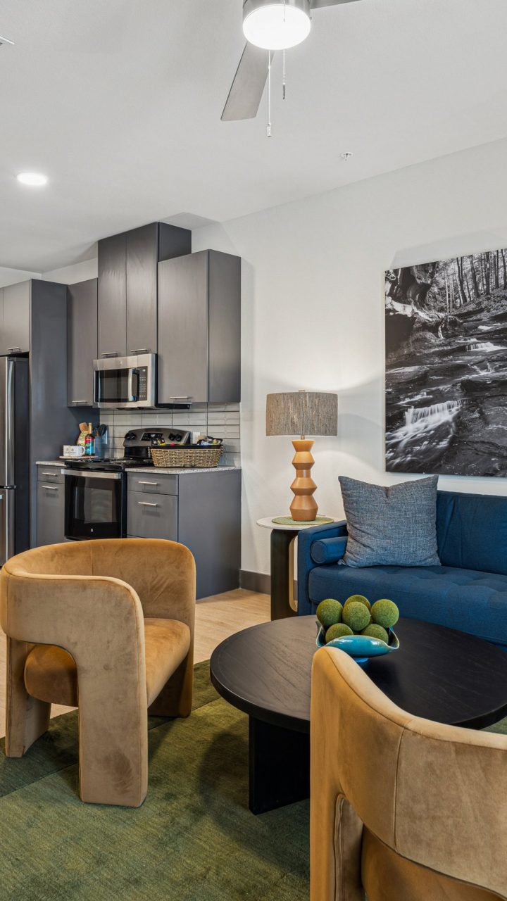 a living room with blue furniture and a blue couch at The Legacy at Veramendi