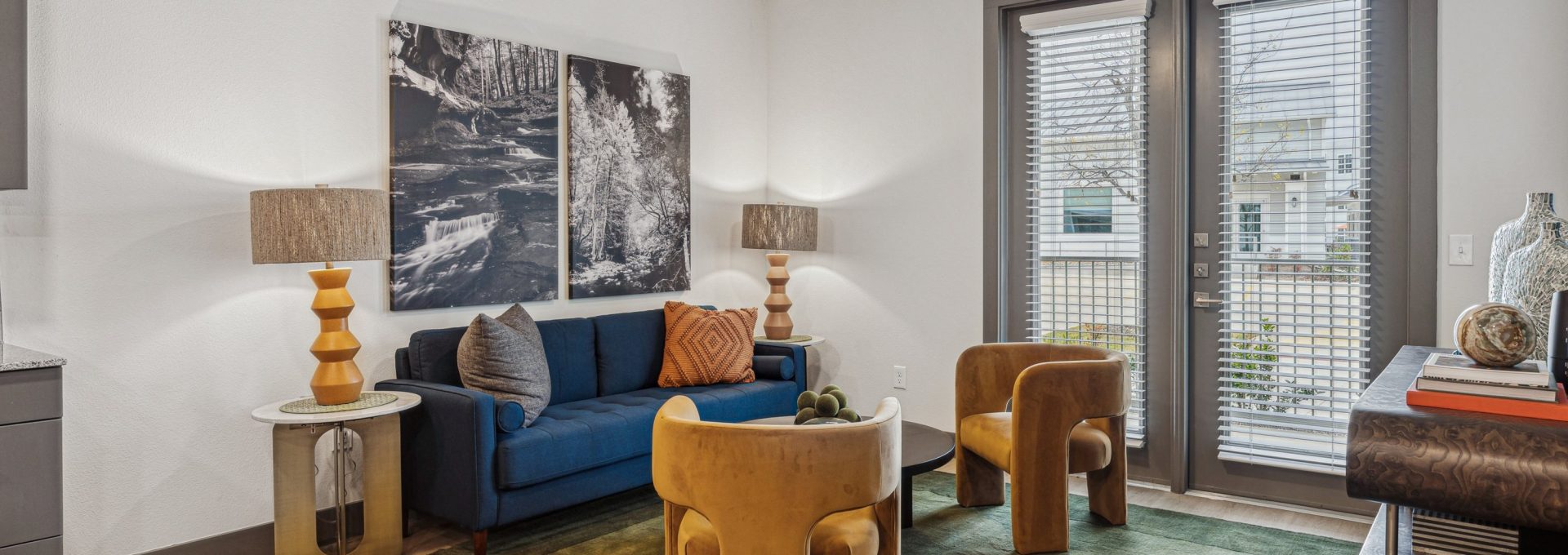 a living room with a blue couch and a large window at The Legacy at Veramendi