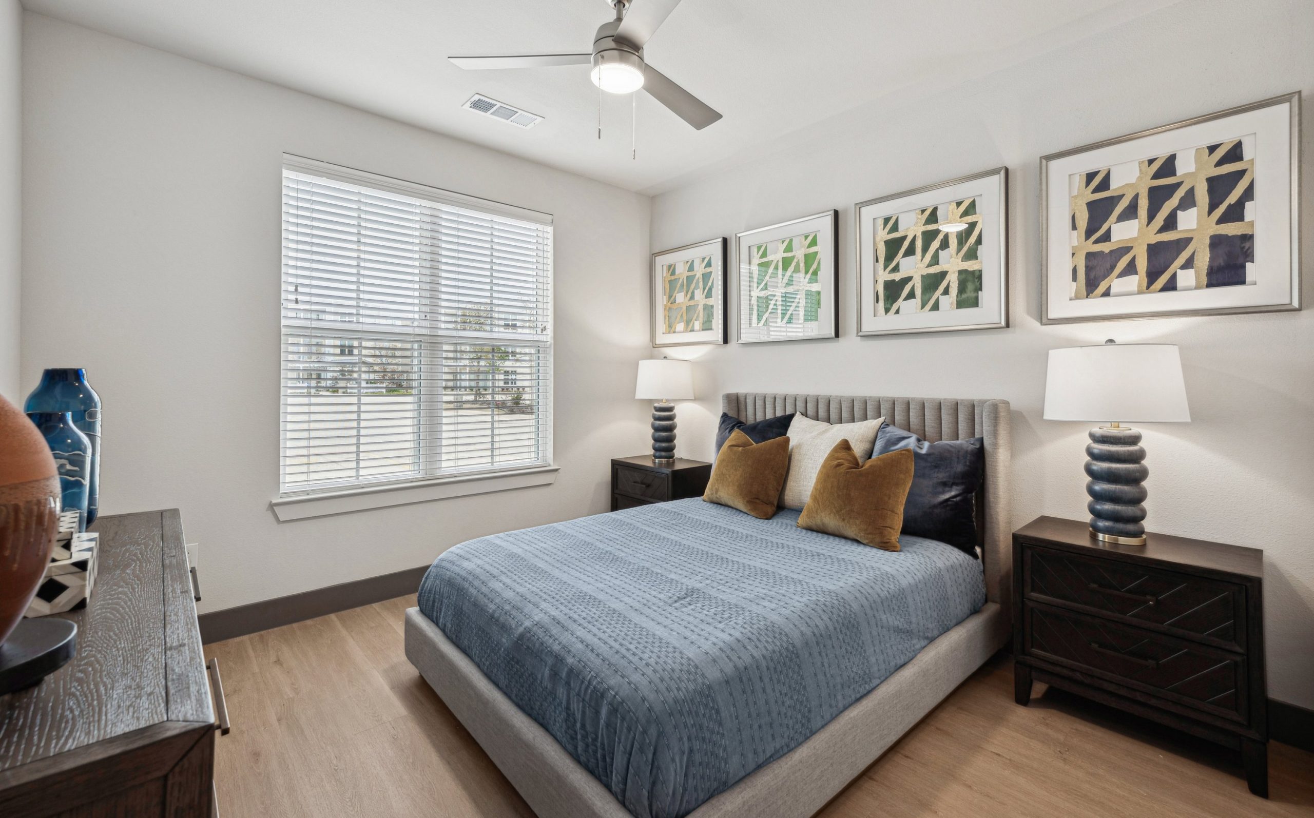 a bedroom with a bed, dresser and pictures on the wall at The Legacy at Veramendi