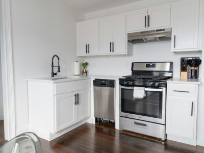 a kitchen with white cabinets and stainless steel appliances at The Tupelo