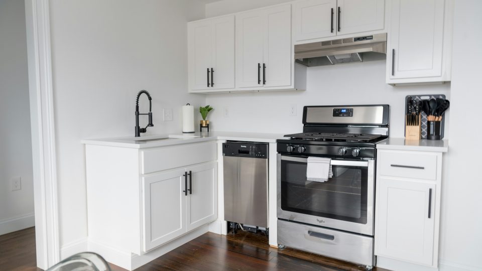 a kitchen with white cabinets and stainless steel appliances at The Tupelo