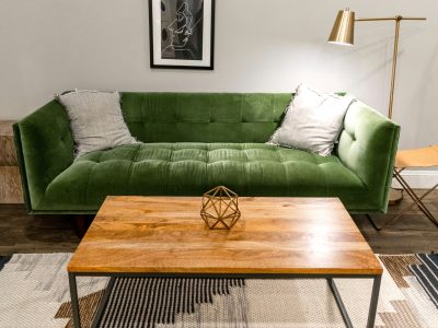 a green couch in a living room with a coffee table at The Tupelo