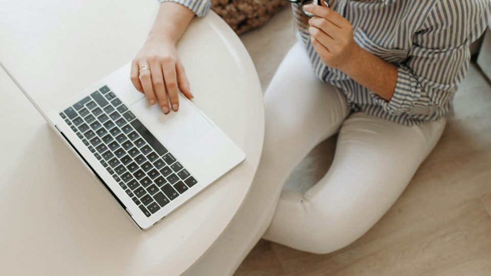 a woman sitting on the floor with a laptop at The Tupelo