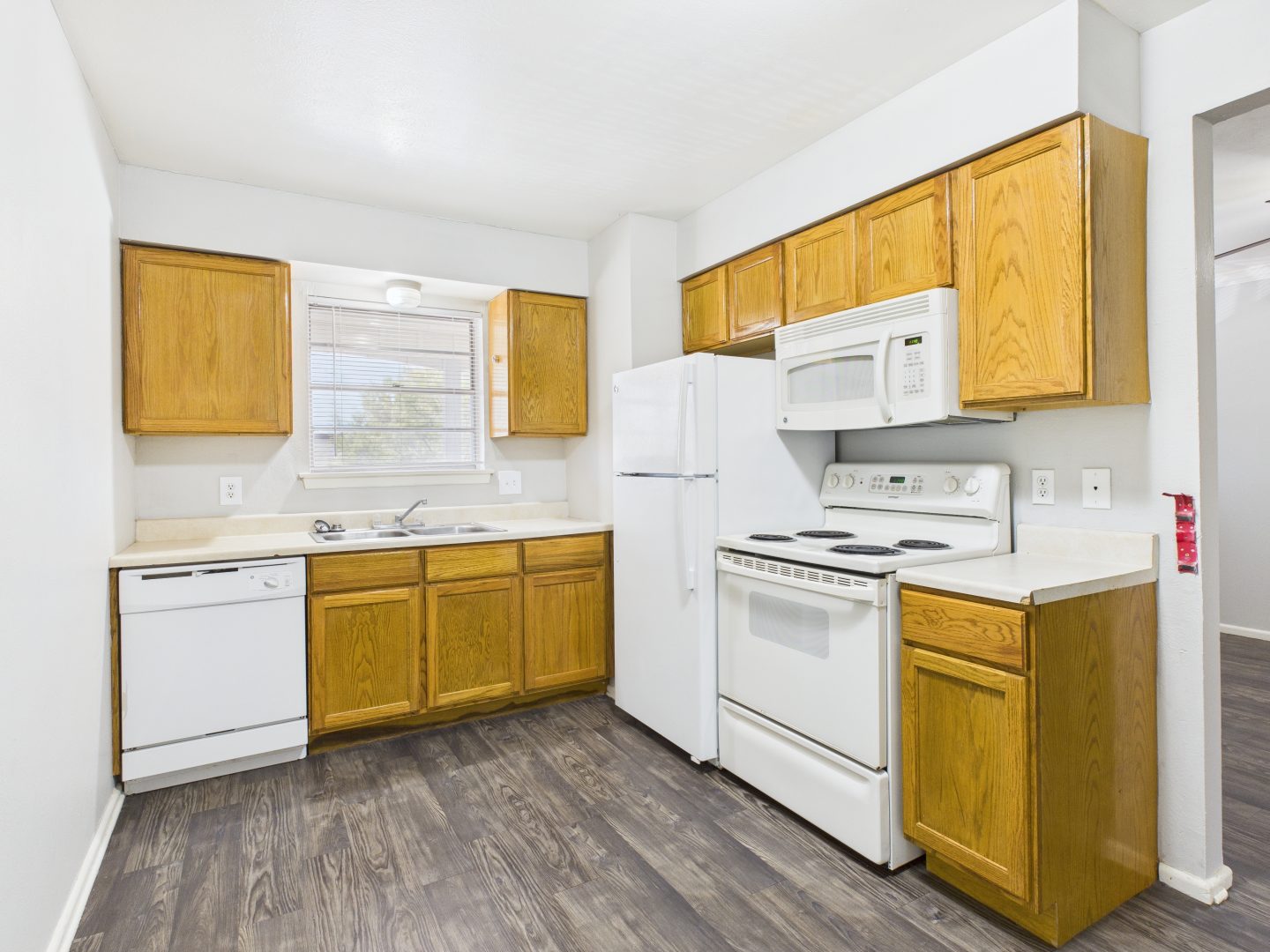 a kitchen with white cabinets and wood floors at The Cielo Vista