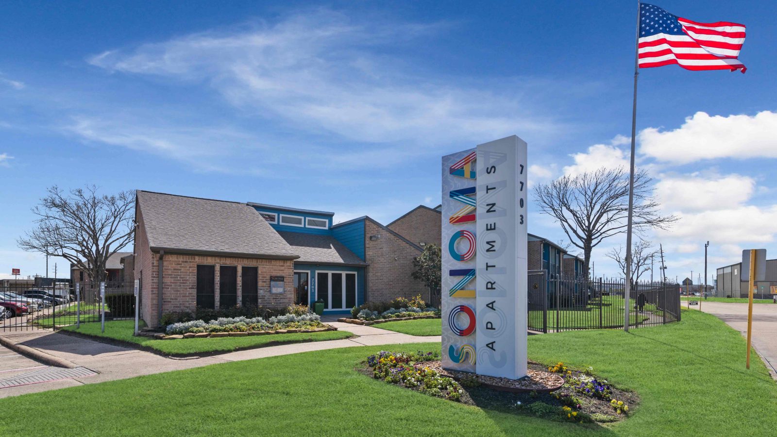 a sign for a business with an american flag at The Sonoma Apartments