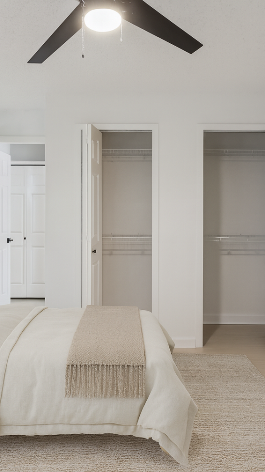 a bedroom with a ceiling fan and white walls at The Vista Bay