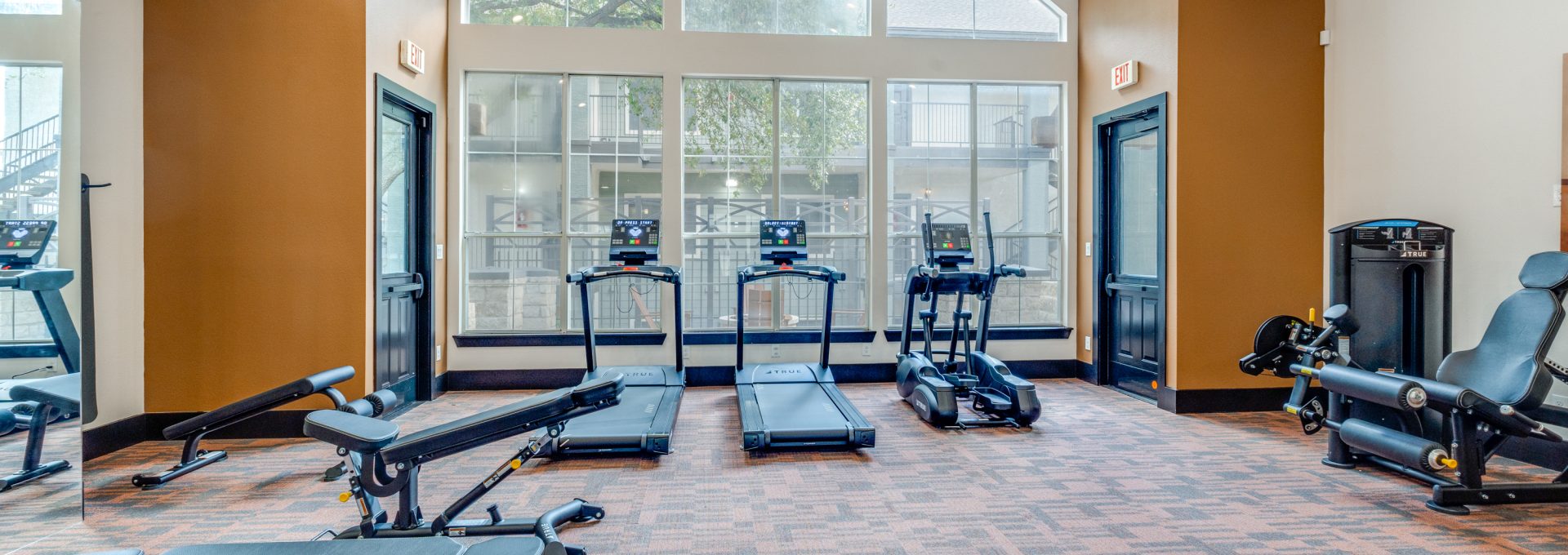 a gym room with exercise equipment and windows at The Stetson