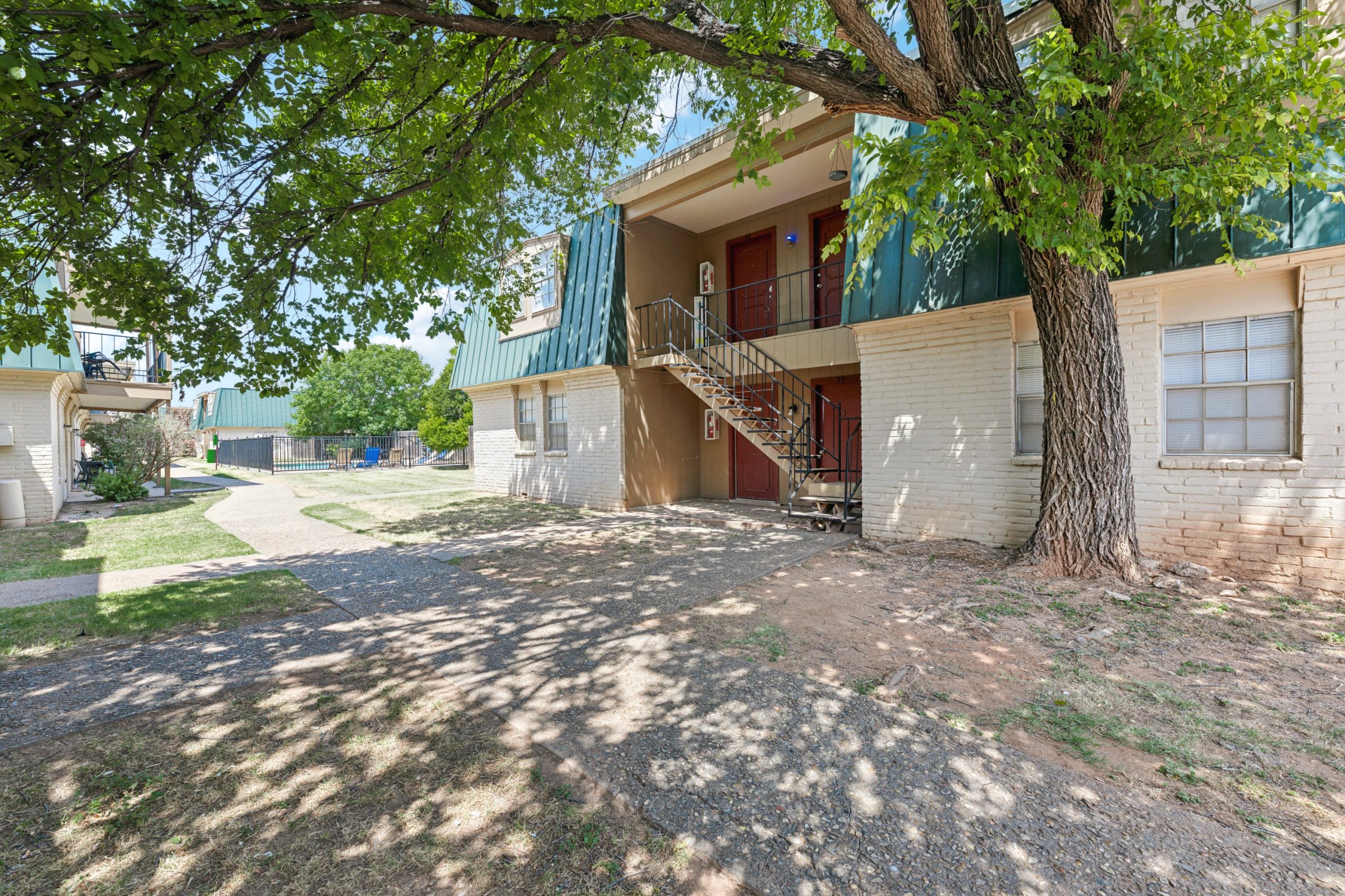 the outside of an apartment building with trees and a sidewalk at The Crestwood Terrace