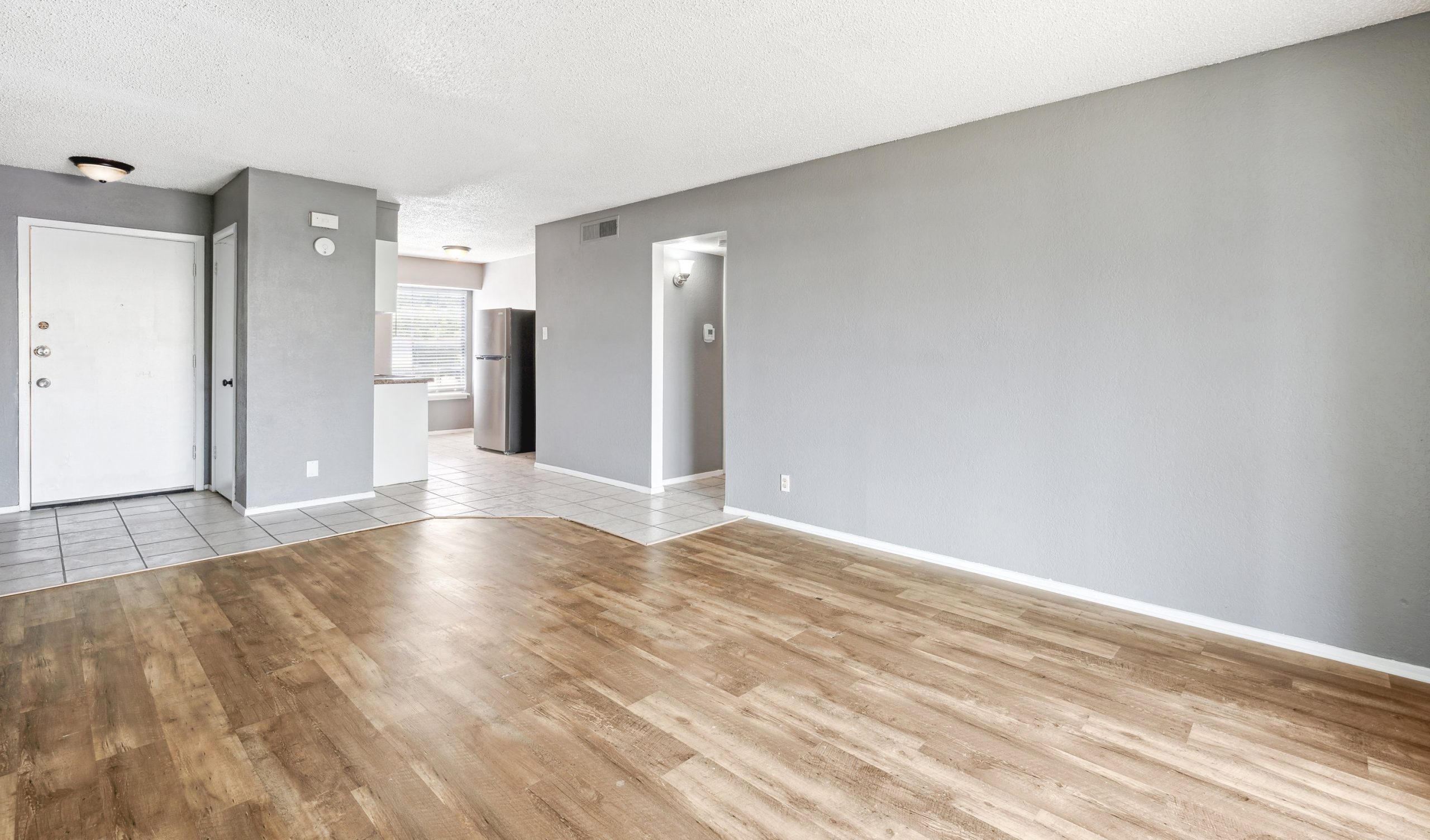an empty room with hardwood floors and gray walls at The Crestwood Terrace