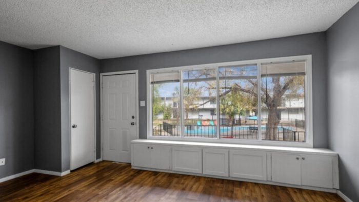 an empty room with a window and hardwood floors at The Arden Arms Apartments