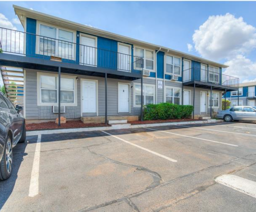 the parking lot at an apartment complex with two cars at The Treehouse