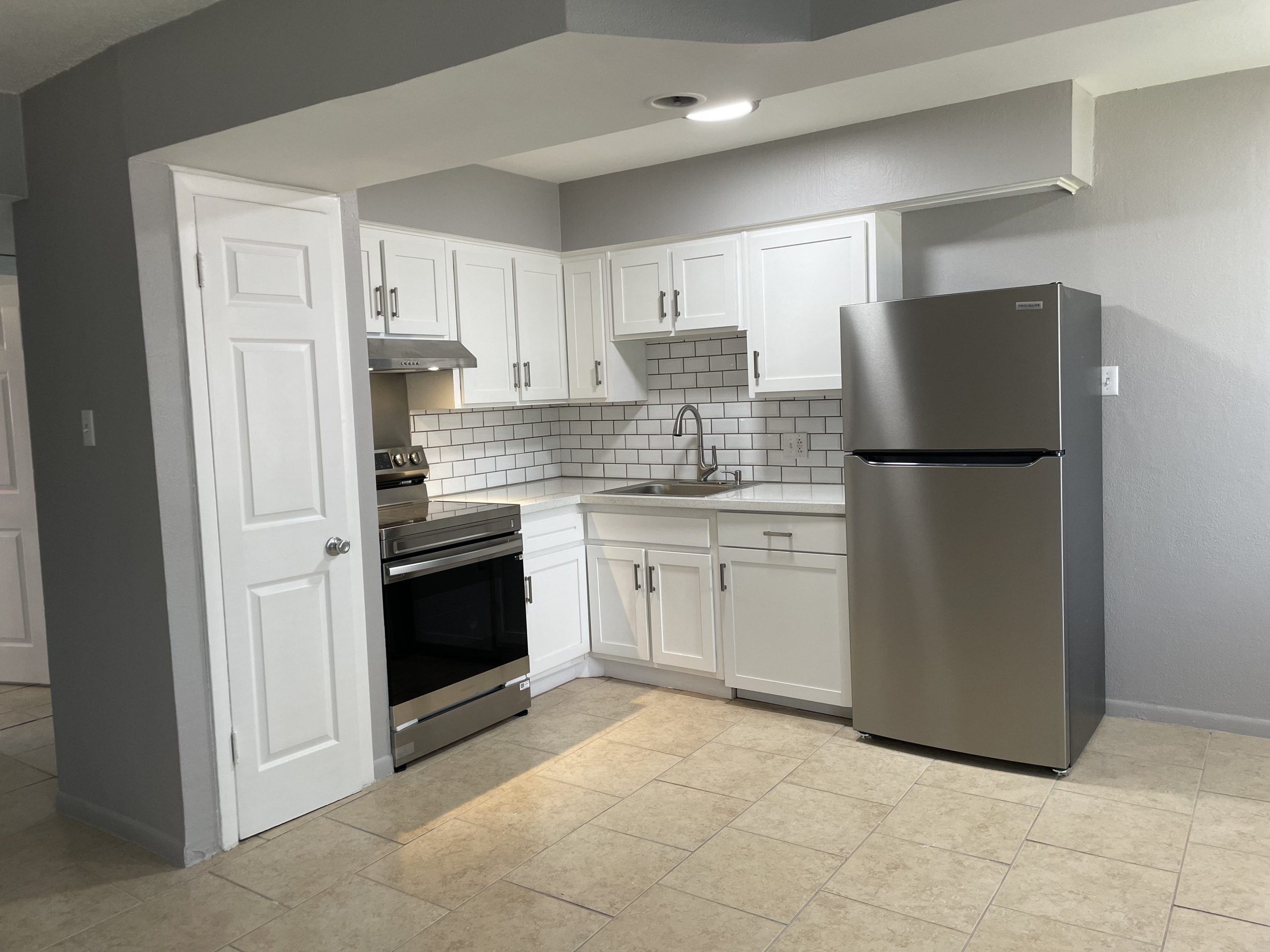 a kitchen with stainless steel appliances and a refrigerator at The HIllshire Village Apartments