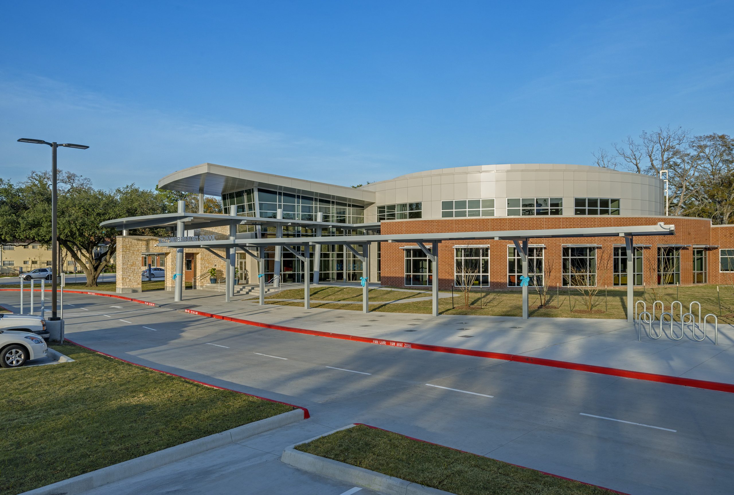 a large building with a parking lot and grass at The Hillshire Village Apartments