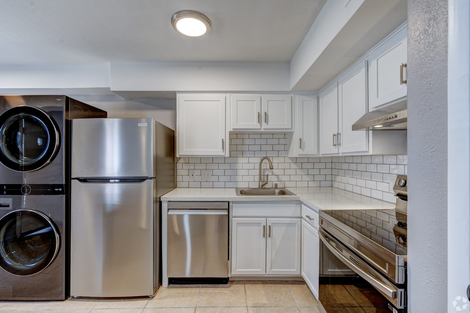 a kitchen with stainless steel appliances and a washer and dryer at The Westview Pines