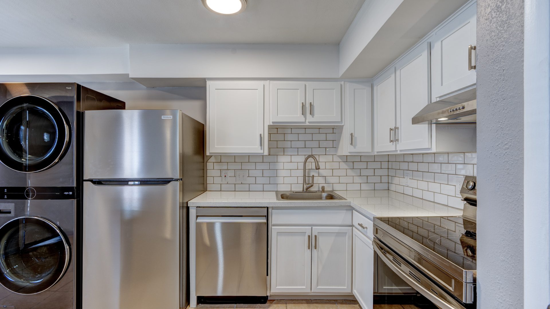a kitchen with stainless steel appliances and a washer and dryer at The Westview Pines