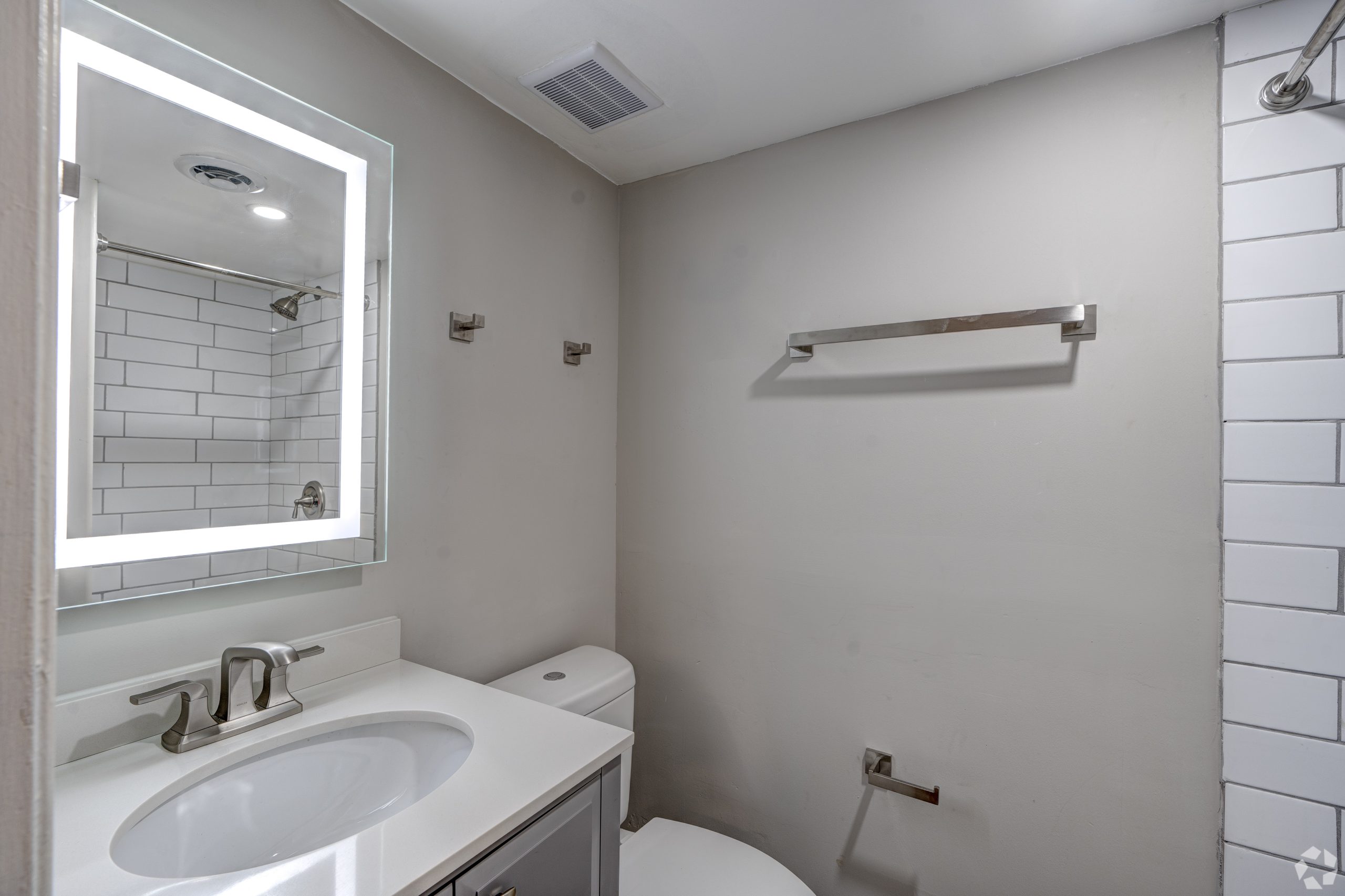 a bathroom with a white toilet, sink and mirror at The Westview Pines