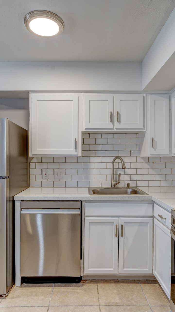 a kitchen with stainless steel appliances and a washer and dryer at The Westview Pines