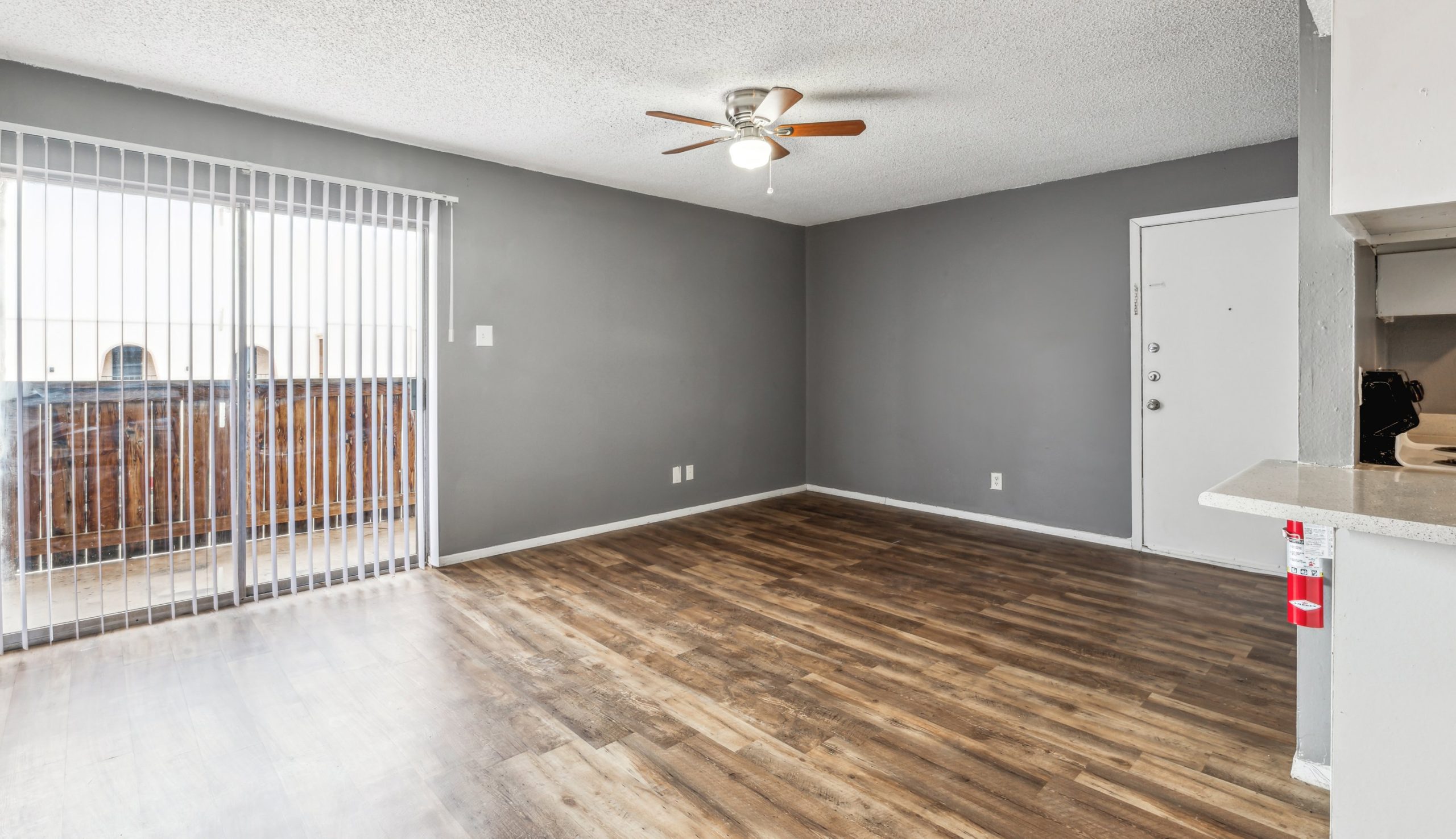 empty room with hardwood floors and ceiling fan at The Alamo Village Apartments