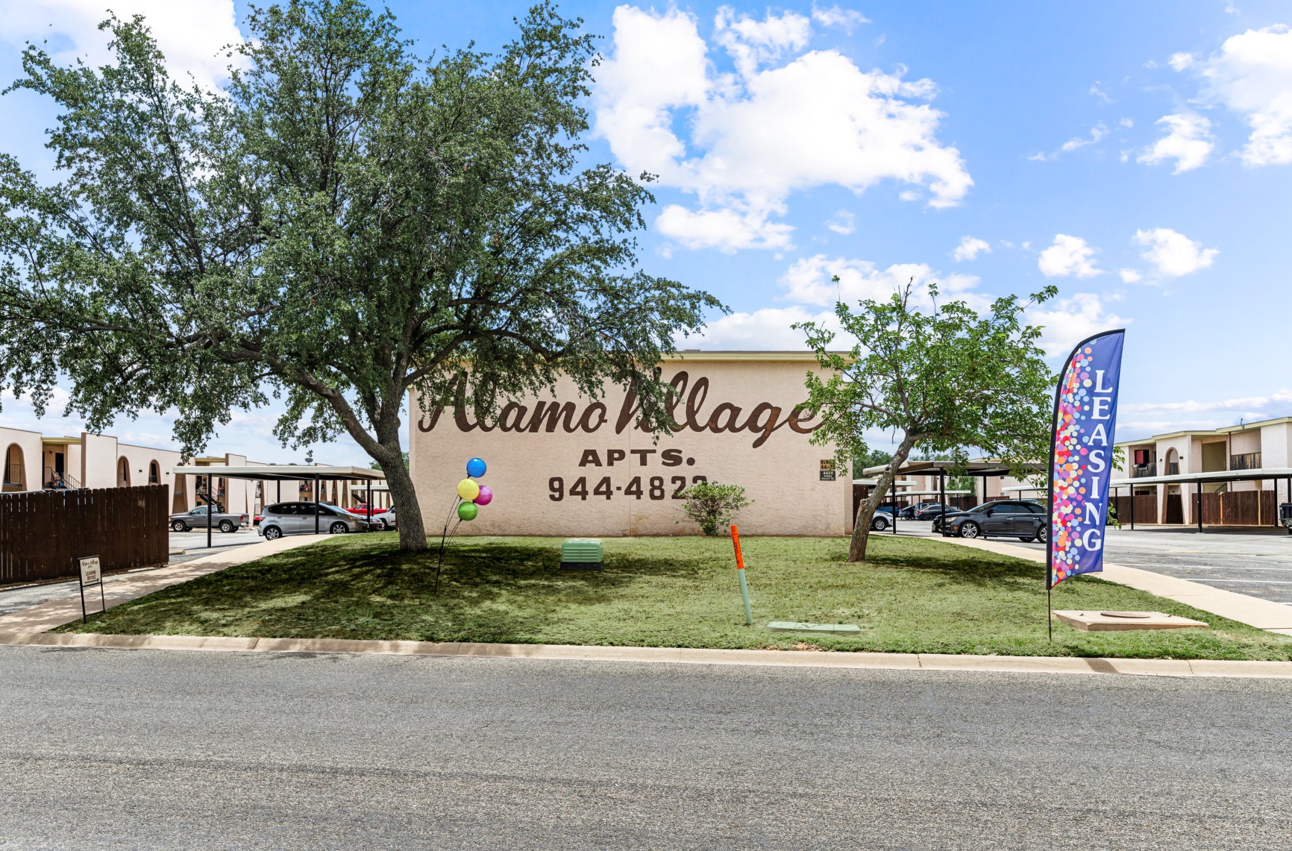 the sign for the village apartments in san antonio at The Alamo Village Apartments