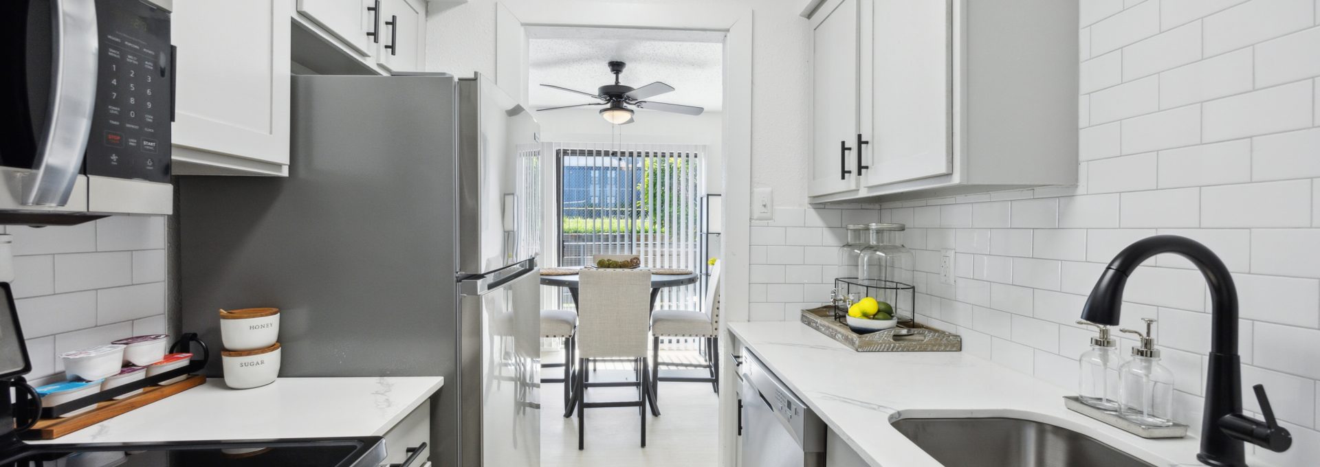 a kitchen with stainless steel appliances and white cabinets at The Brookbend