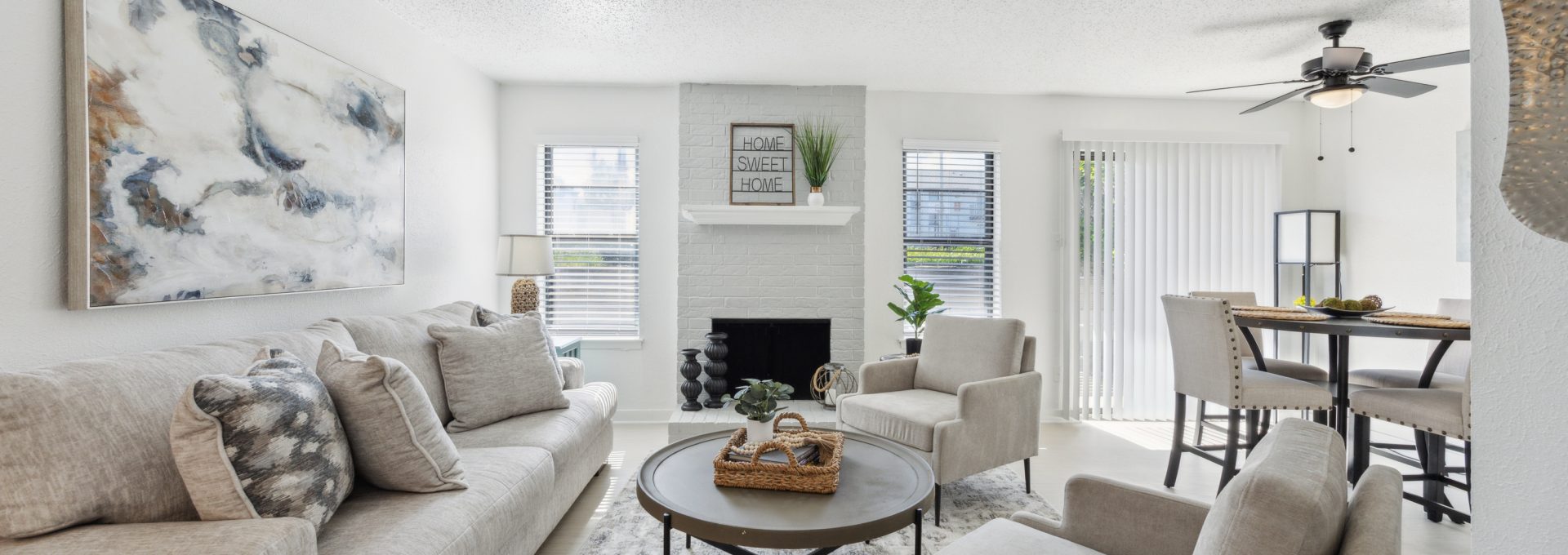 a living room with white furniture and a ceiling fan at The Brookbend