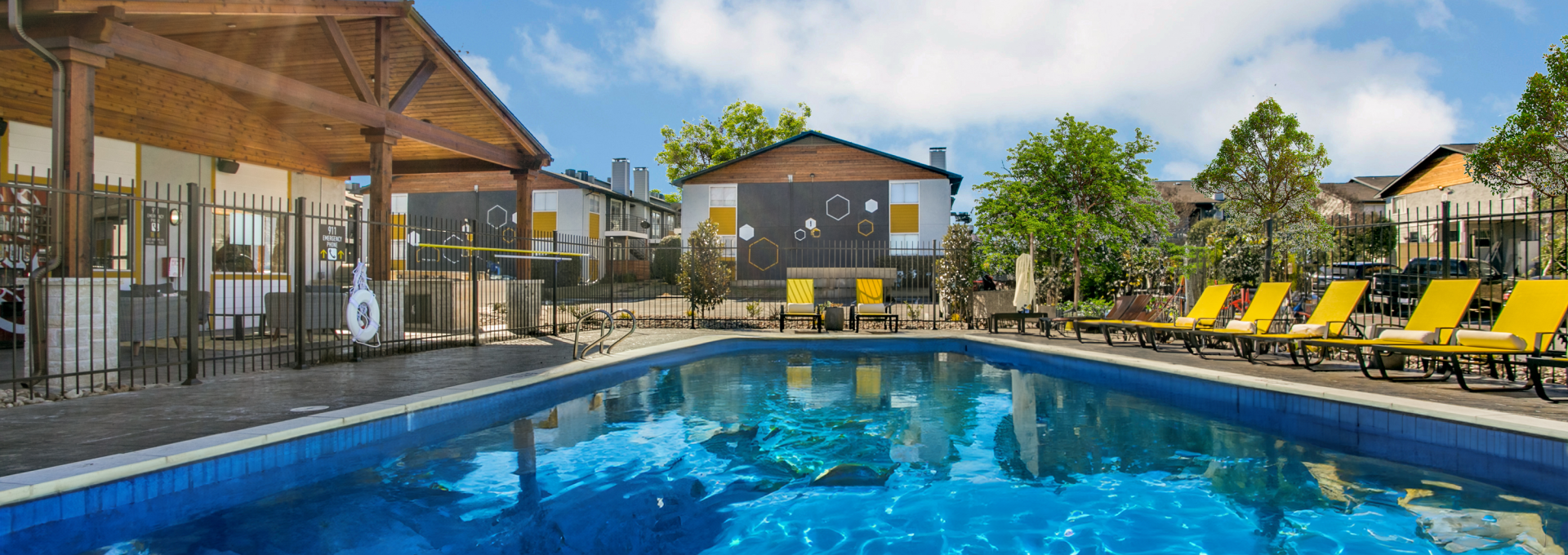 a pool with lounge chairs and umbrellas at The  Hive