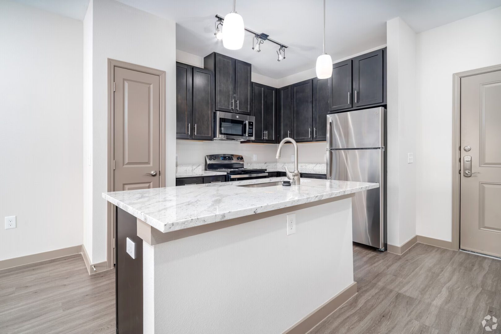 a kitchen with stainless steel appliances and wood floors at The Barons Park