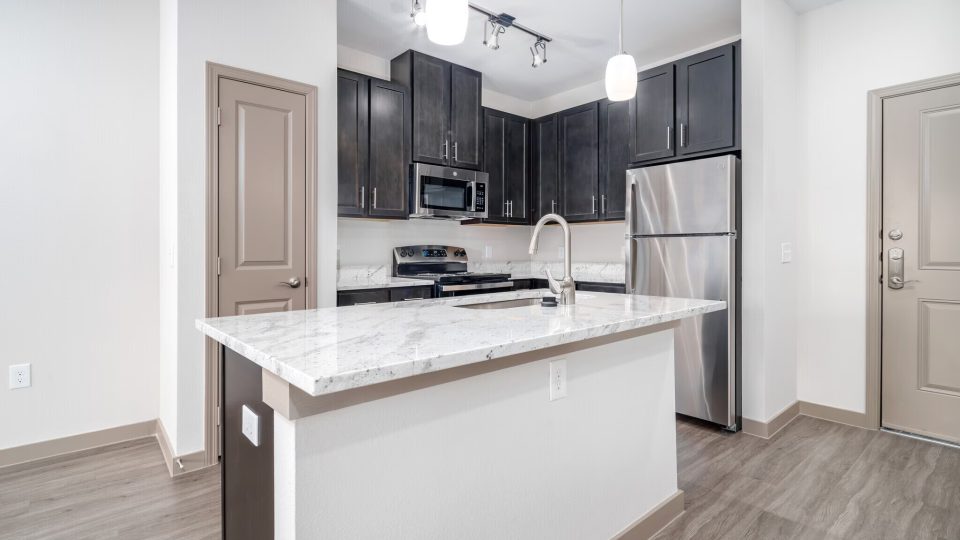 a kitchen with stainless steel appliances and wood floors at The Barons Park